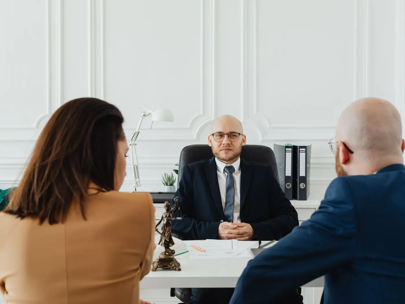 Avocat recevant un couple en rendez-vous dans un cabinet lumineux