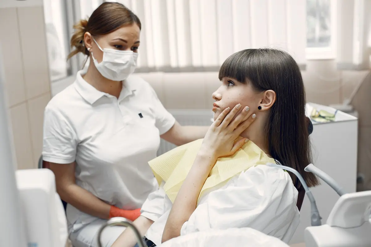 Patiente souffrant d'une rage de dents examinée par la dentiste