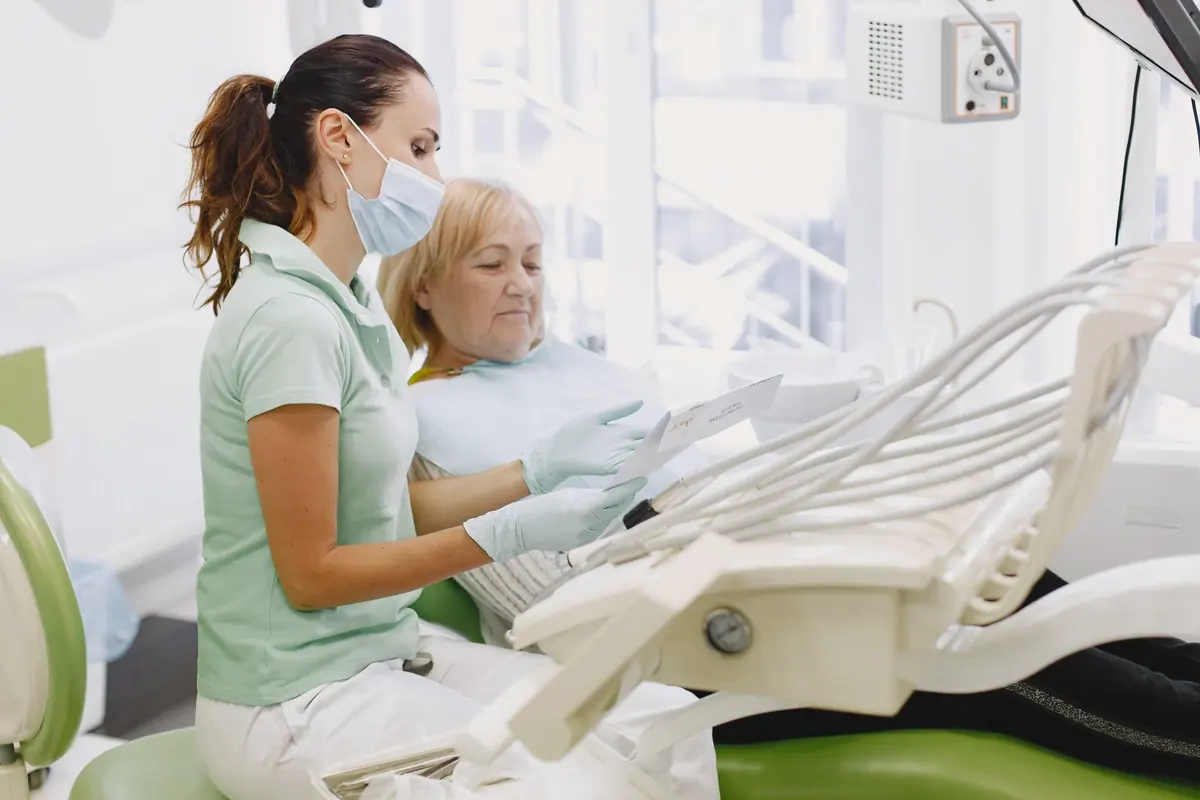 Dentiste expliquant son diagnostic à une patiente âgée