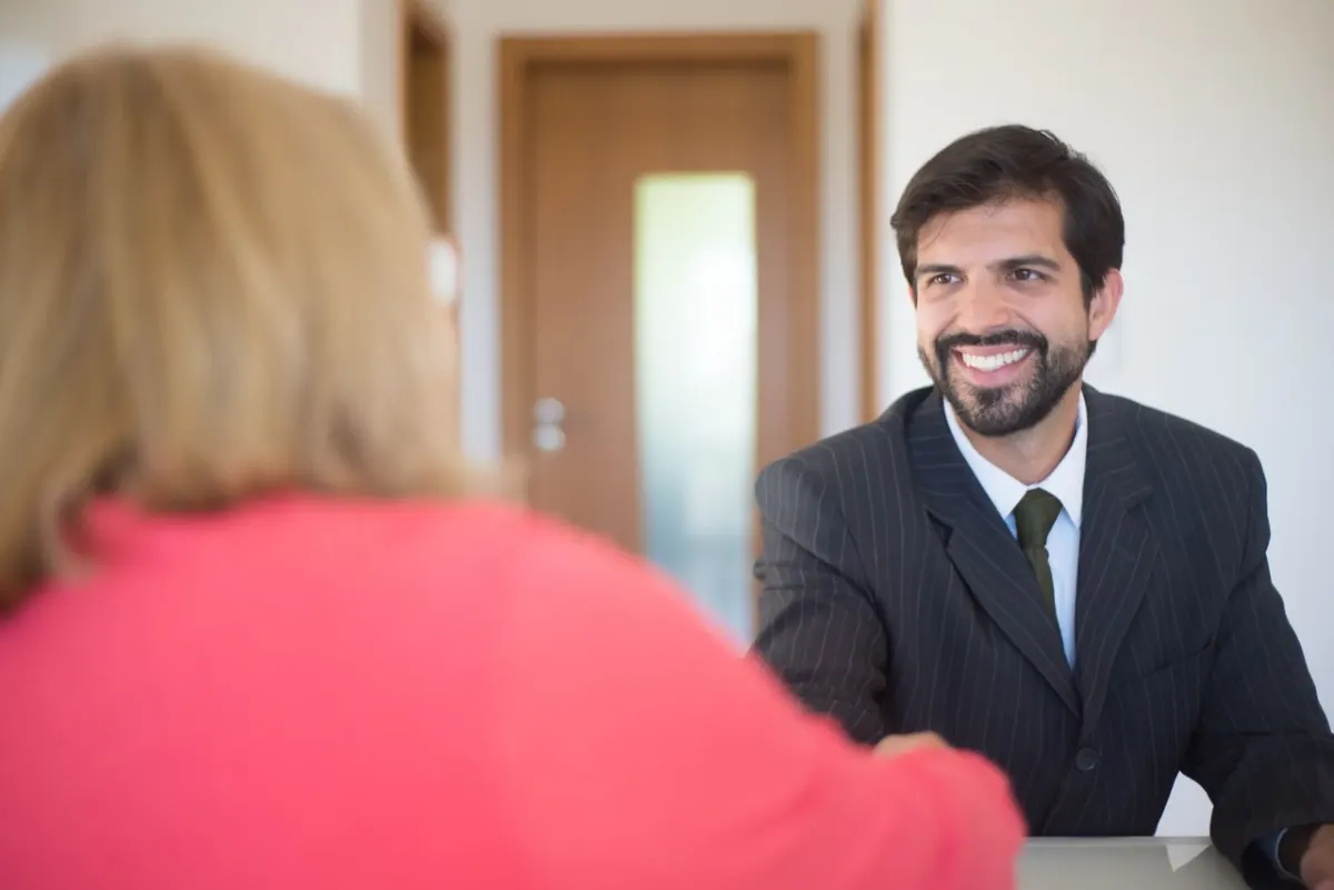Expert-comptable souriant qui serre la main d'un client dans son bureau, relation de confiance