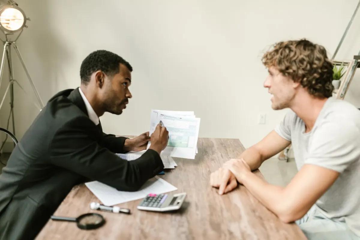Expert-comptable en rendez-vous avec un client dans un bureau moderne, documents sur la table