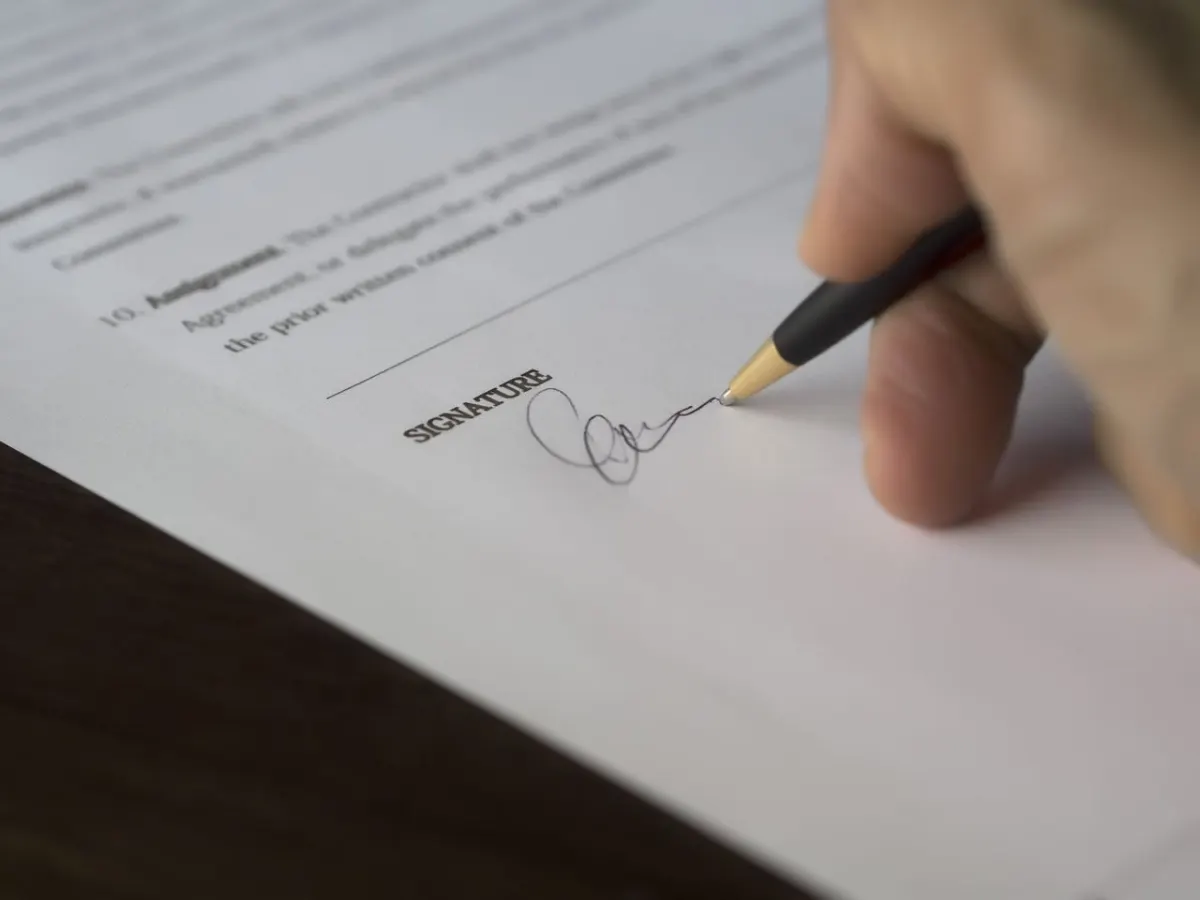 Signature d'un acte officiel au stylo sur un bureau, chez le notaire à Montpellier