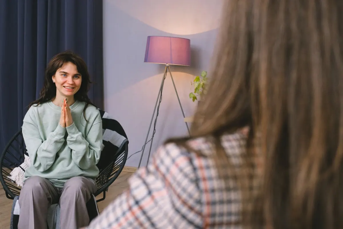 Patiente souriante et apaisée en échange avec sa psychologue dans un cabinet moderne