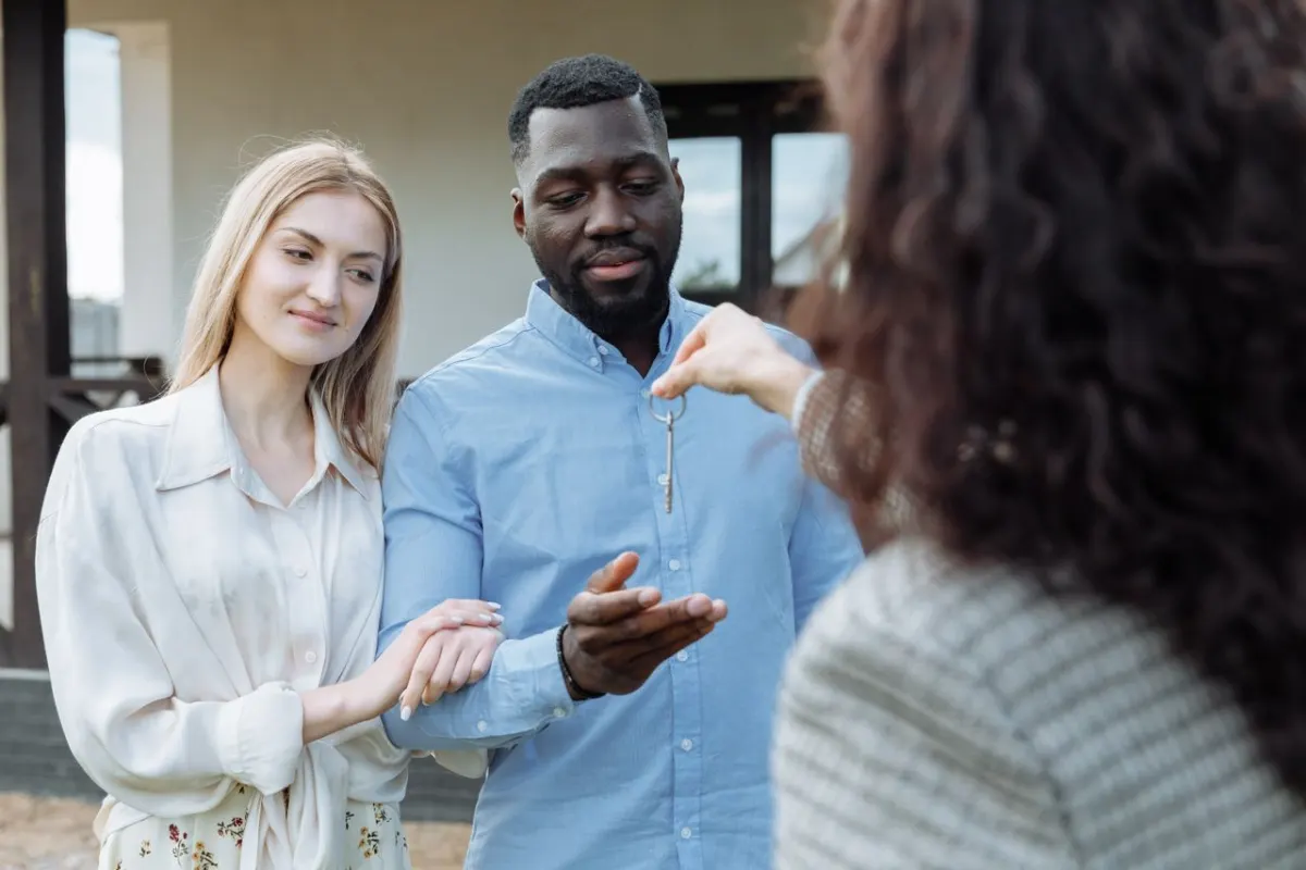 Couple rassuré qui reçoit les clés devant sa porte après une intervention